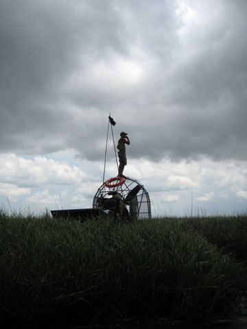 An airboat driver tries to get a better cell phone signal