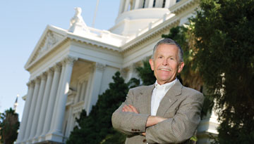 Photo: Huckfeldt, smiling with arms crossed in front of California capitol