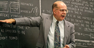 Photo: professor gesturing at blackboard