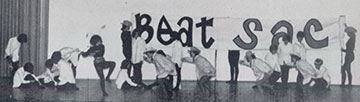 a yearbook photo of a dorm residents performing a pre-game skit and sign that reads Beat Sac