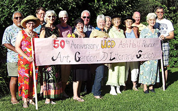 Reunino group holding a sign for 50th annivesary of the drill team