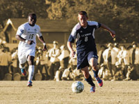 Two soccer players, one from UC Davis and one from Sacramento State, chase the ball