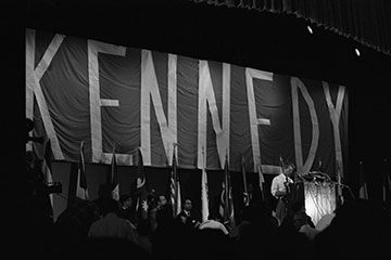 Photo: The 1968 presidential candidate on stage with large banner behind him that reads Kennedy