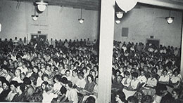 Photo: students sitting in rows in a gymnasium