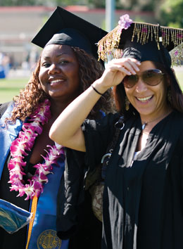 Photo: two smiling graduates at commencement ceremony