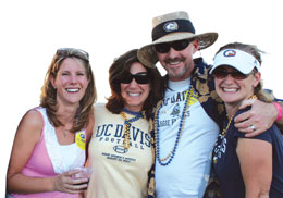 Photo:  Four alumni in UC Davis hats and shirts