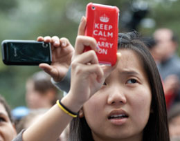 Photo: student recording images of rally with cell phone. Case reads: Keep Calm and Carry On