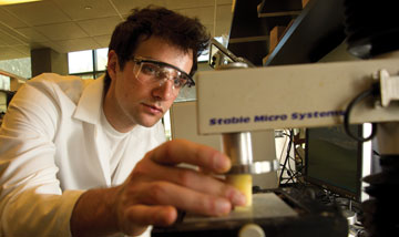 Graduate student putting potato core sample into scientific instrument
