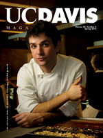 Cover photo: young food scientist in white coat leaning over table with pan of chocolate