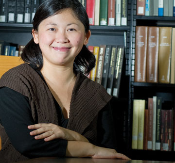 Photo: the English professor and author, smiling, seated in front of bookcase