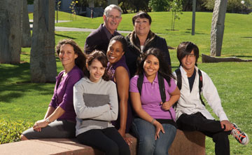Photo: outdoor portrait of alumni couple with five students